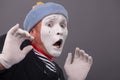 Portrait of young male mime with white face, grey Royalty Free Stock Photo