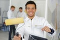 Portrait young male painter holding bucket and roller Royalty Free Stock Photo