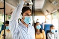 Focused business man in mask listening to music riding bus Royalty Free Stock Photo