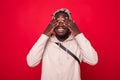 Portrait, young male, shy man closing covering eyes with hands cant see, hiding, isolated red background. See no evil concept.