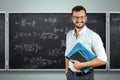 Portrait of a young male teacher on the background of the school blackboard. Teacher`s Day Knowledge Day back to school study Royalty Free Stock Photo