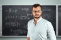 Portrait of a young male teacher on the background of the school blackboard. Teacher`s Day Knowledge Day back to school study Royalty Free Stock Photo