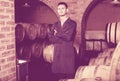 Portrait of young male wine maker in coat working in winery cell Royalty Free Stock Photo