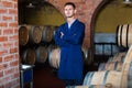 Portrait of young male wine maker in coat working in winery cell Royalty Free Stock Photo