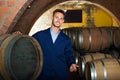 Portrait of young male wine maker in coat working in winery cell Royalty Free Stock Photo