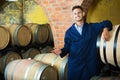 Portrait of young male wine maker in coat working in winery cell Royalty Free Stock Photo