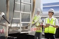 Young male worker using tablet PC as he inspects oil tanker Royalty Free Stock Photo