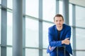 Portrait of young man in airport. Casual young boy wearing suit jacket. Caucasian man with cellphone at the airport Royalty Free Stock Photo