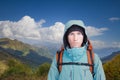 Portrait of young man with backpack on the background of a mountain landscape and a blue sky with white clouds. Mountain Royalty Free Stock Photo