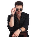 Portrait of young man at bar table arranging his sunglasses Royalty Free Stock Photo