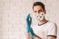 Young male doctor in flower medical face mask wearing protective latex gloves Royalty Free Stock Photo