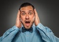 Portrait young man in blue shirt, looking with amazement Royalty Free Stock Photo