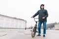 Young man standing with a BMX bike against the city background. BMX rider stands with a bike. BMX concept