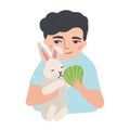 Portrait of young man or boy holding his bunny or rabbit and feeding it. Adorable male cartoon character with domestic Royalty Free Stock Photo