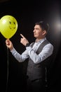 Portrait of a young man in a business suit and wigh with balloons. Positive guy posing in the studio Royalty Free Stock Photo