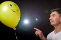 Portrait of a young man in a business suit and wigh with balloons. Positive guy posing in the studio Royalty Free Stock Photo