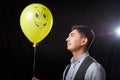 Portrait of a young man in a business suit and wigh with balloons. Positive guy posing in the studio Royalty Free Stock Photo