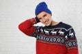 Portrait of young man in Christmas sweater and hat Royalty Free Stock Photo
