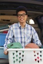 Portrait of young man with college dorm items in back of car, looking at camera Royalty Free Stock Photo