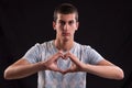 Portrait of young man doing a heart gesture Royalty Free Stock Photo