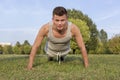 Portrait of young man doing pushups in park Royalty Free Stock Photo