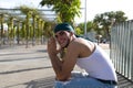 Portrait of a young man dressed in jeans and white t-shirt. The young man is sitting on a park bench and makes different Royalty Free Stock Photo