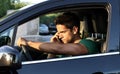 Portrait of young man driving with mobile phone