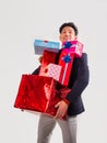 Portrait of young man dropping pile of presents and gifts