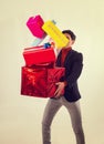 Portrait of young man dropping pile of presents and gifts