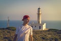 Young man in the evening sun, with a lighthouse in background Royalty Free Stock Photo