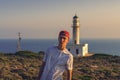 Young man in front of a lighthouse in Greece Royalty Free Stock Photo