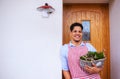 A portrait of young man gardener standing in front of door at home. Copy space. Royalty Free Stock Photo