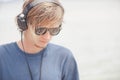 Portrait of young man in headphones and sunglasses at the beach Royalty Free Stock Photo