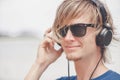 Portrait of young man in headphones and sunglasses at the beach Royalty Free Stock Photo