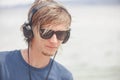 Portrait of young man in headphones and sunglasses at the beach Royalty Free Stock Photo