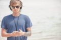 Portrait of young man in headphones and sunglasses at the beach Royalty Free Stock Photo