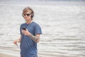 Portrait of young man in headphones and sunglasses at the beach Royalty Free Stock Photo