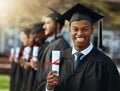 Imagine the doors this could open. Portrait of a young man holding his diploma while standing with his fellow students Royalty Free Stock Photo