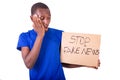 Portrait of a young man holding a poster, frightened