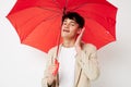 portrait of a young man holding an umbrella in the hands of posing fashion light background unaltered Royalty Free Stock Photo