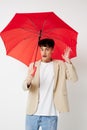 portrait of a young man holding an umbrella in the hands of posing fashion light background unaltered Royalty Free Stock Photo