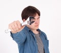 Portrait of young man while holding wrench on white background Royalty Free Stock Photo