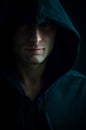 Portrait of a young man with a hood covering his head and keeping his gaze in the shadows Royalty Free Stock Photo