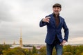 Portrait of a young man in a jacket and cap. The guy shows the Rock Symbol (Sign of the horns) gesture. Royalty Free Stock Photo