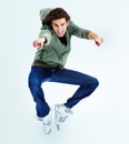 Cmon, its fun. Portrait of a young man jumping up in the air while pointing at you. Royalty Free Stock Photo