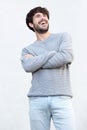 Young man laughing with arms crossed against white background Royalty Free Stock Photo