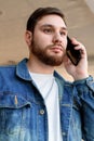 Portrait young man making call. Caucasian bearded business man have mobile conversation, talking by phone indoors Royalty Free Stock Photo
