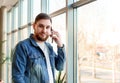 Portrait young man making call. Caucasian bearded business man in modern city office have mobile conversation, talking by phone Royalty Free Stock Photo