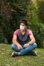 Young man with a mask in a park, surrounded by nature. outdoor