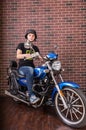 Portrait of Young Man on Motorcycle by Brick Wall Royalty Free Stock Photo